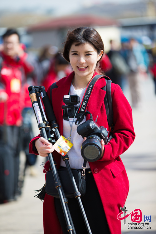2016年兩會，人民大會大堂前，一位笑容燦爛的紅衣女記者正步入大會堂。中國網(wǎng) 鄭亮 攝