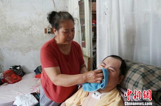每次喂完食物后，梁青蘭都要仔細(xì)地幫兒子清理干凈?！∩忻鱾b 攝