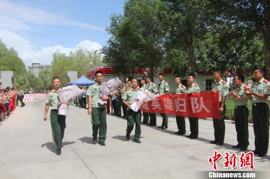部隊官兵們迎接出院歸來的李運飛(中)和其他消防戰(zhàn)士。　汪渝 攝