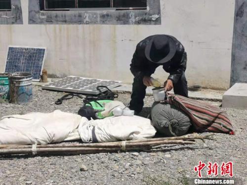 圖為黨確桑布展示以前巡邊時(shí)要帶的東西。 謝藝觀 攝