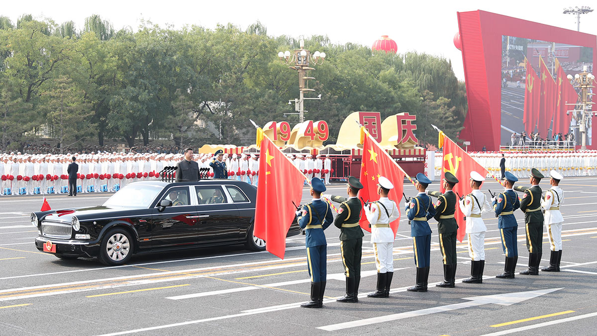 習(xí)近平驅(qū)車行進(jìn)至黨旗、國旗、軍旗前，向旗幟行注目禮