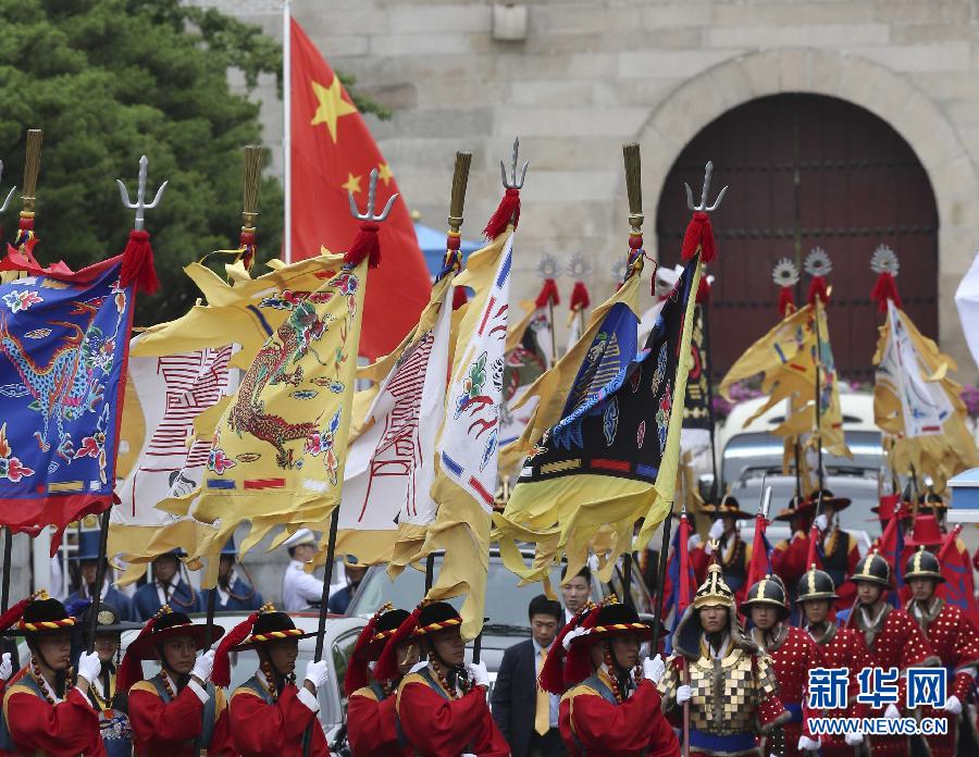 7月3日，韓國總統(tǒng)樸槿惠在青瓦臺(tái)總統(tǒng)府舉行隆重儀式，歡迎中國國家主席習(xí)近平對(duì)韓國進(jìn)行國事訪問。這是習(xí)近平的車隊(duì)在身著民族服裝的韓國禮儀隊(duì)伍引導(dǎo)下駛?cè)肭嗤吲_(tái)。新華社記者丁林?jǐn)z  